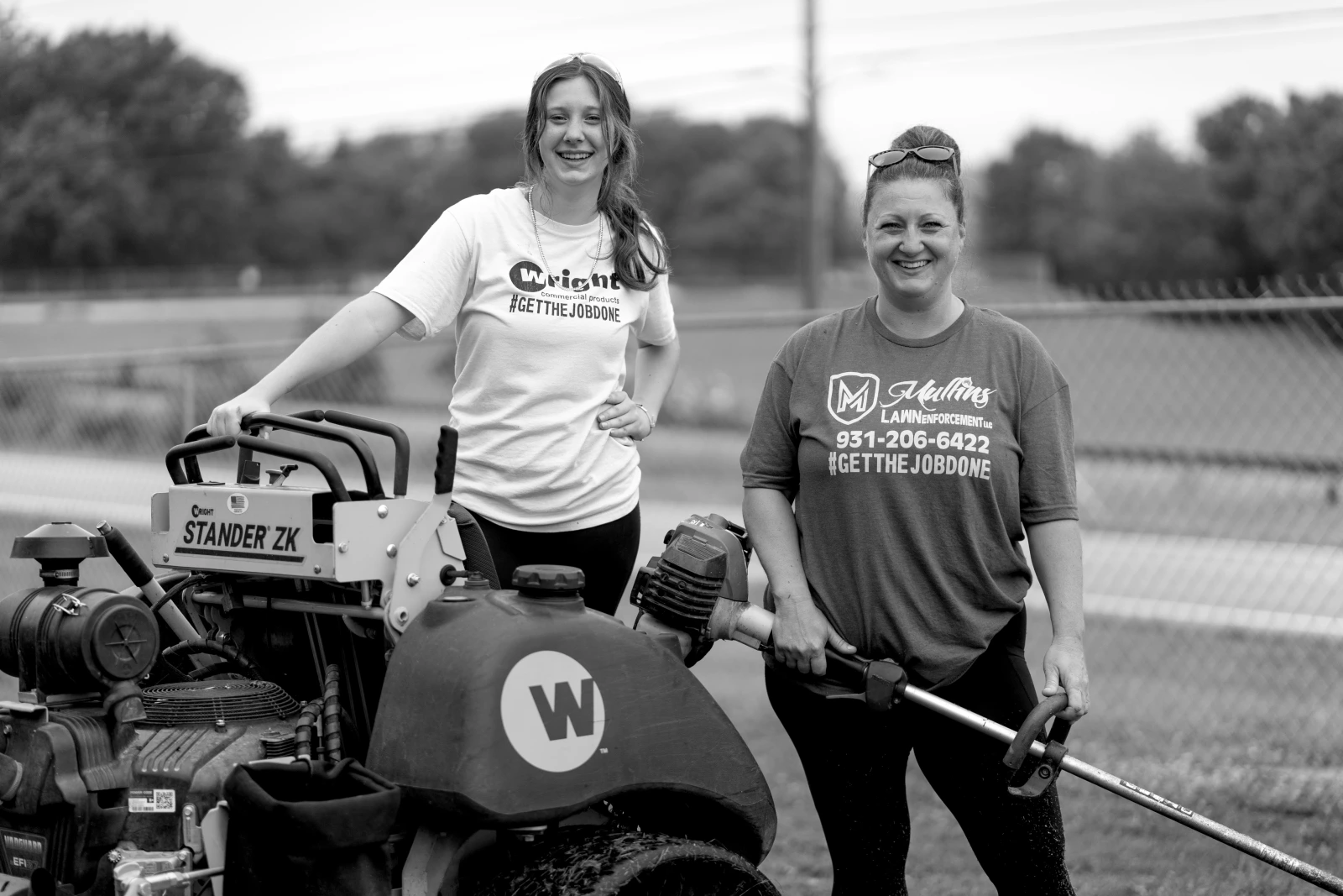 Two woman standing with lawncare equipment