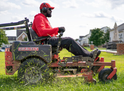 man riding lawn mower and mowing lawn