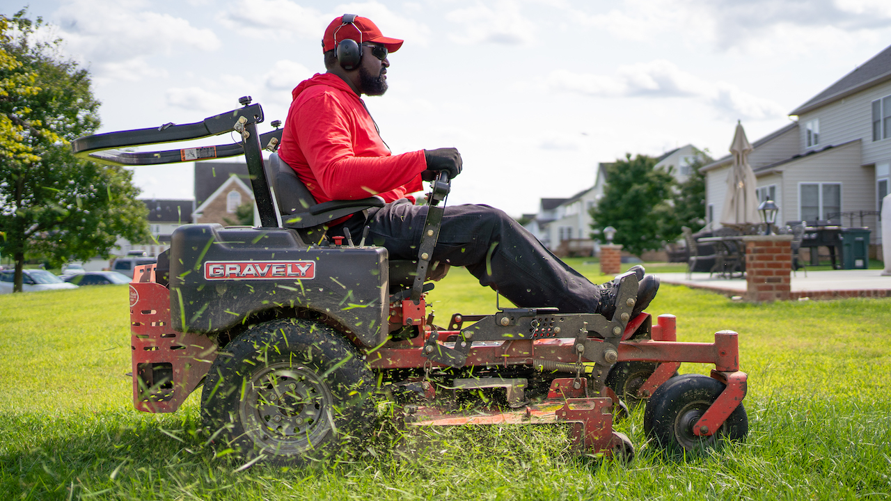 man riding lawn mower and mowing lawn