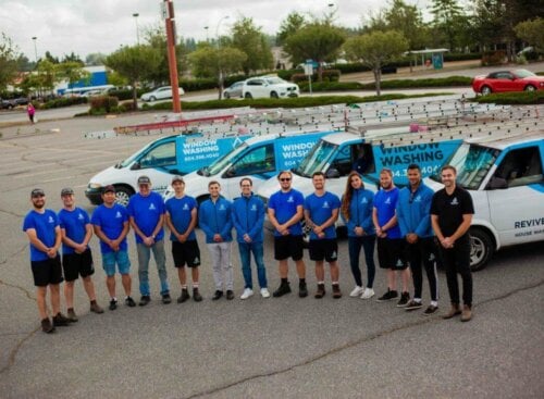 Pressure washing team standing in front of vehicle fleet