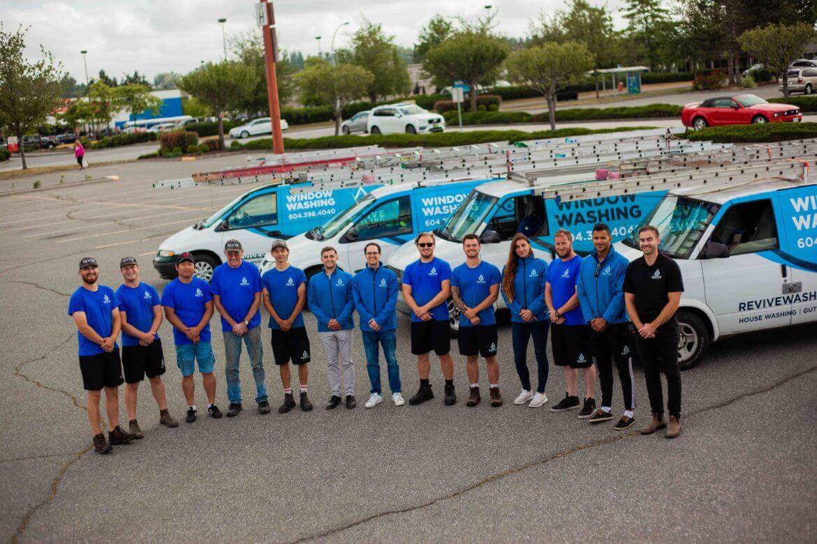 Pressure washing team standing in front of vehicle fleet