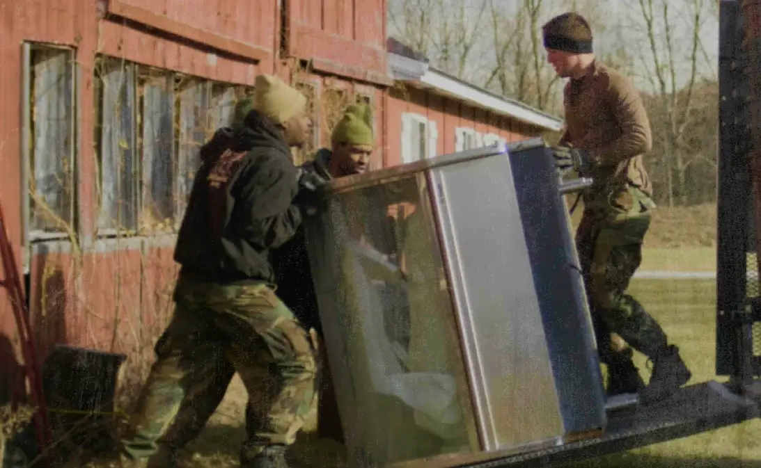 image of junk removal professionals hauling junk after using Jobber's junk removal software
