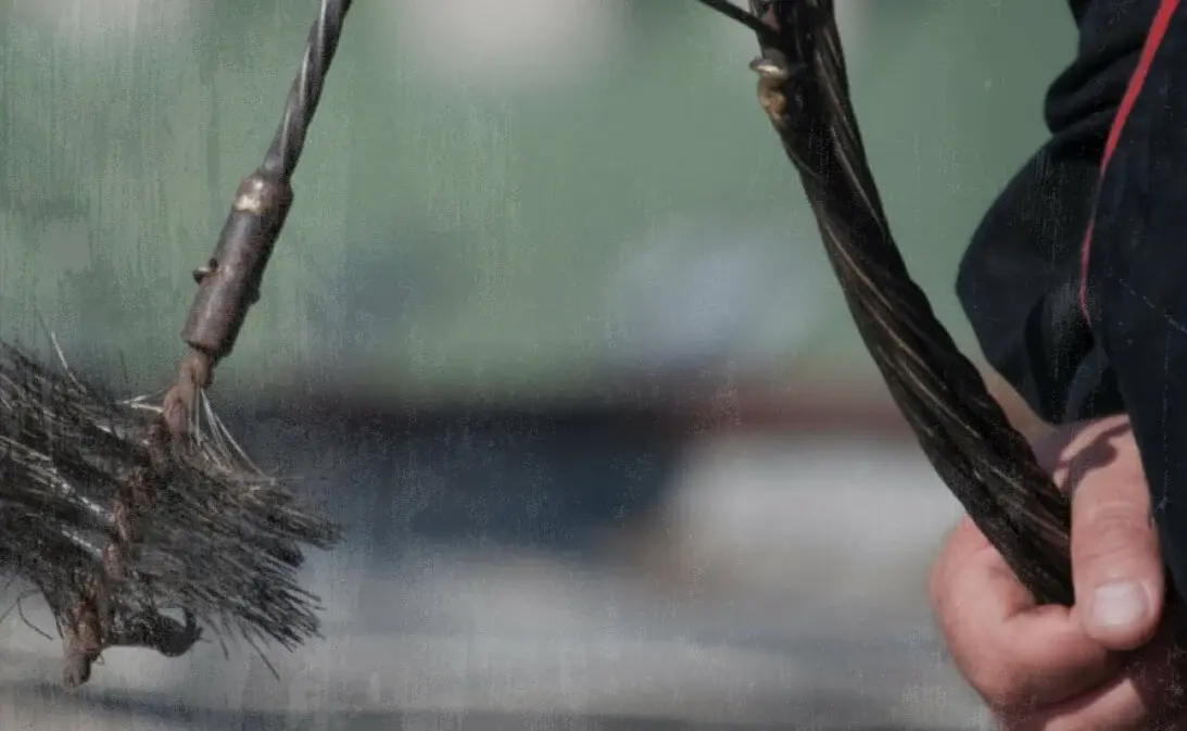 image of service provider holding a chimney sweep brush after using Jobber's chimney sweep software