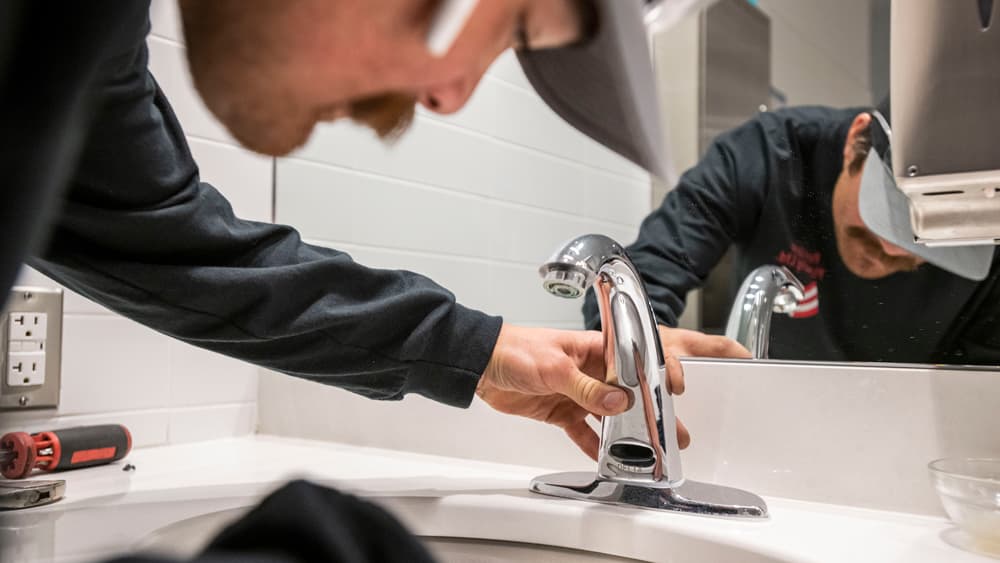 image of plumber repairing faucet
