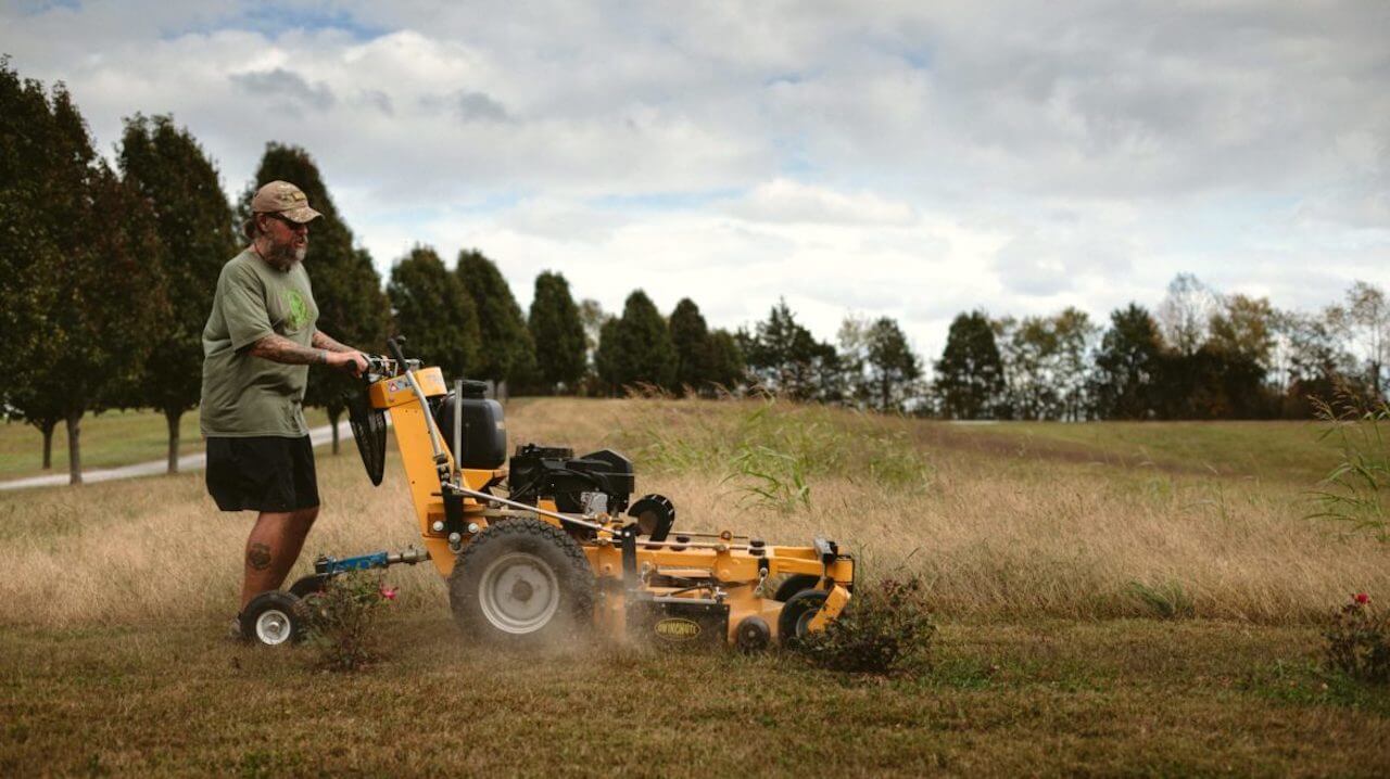 image of a lawn care contractor mowing a large field