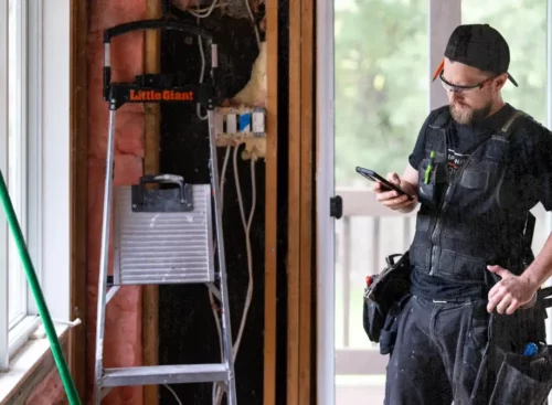 image of construction business owner using construction software on his mobile device