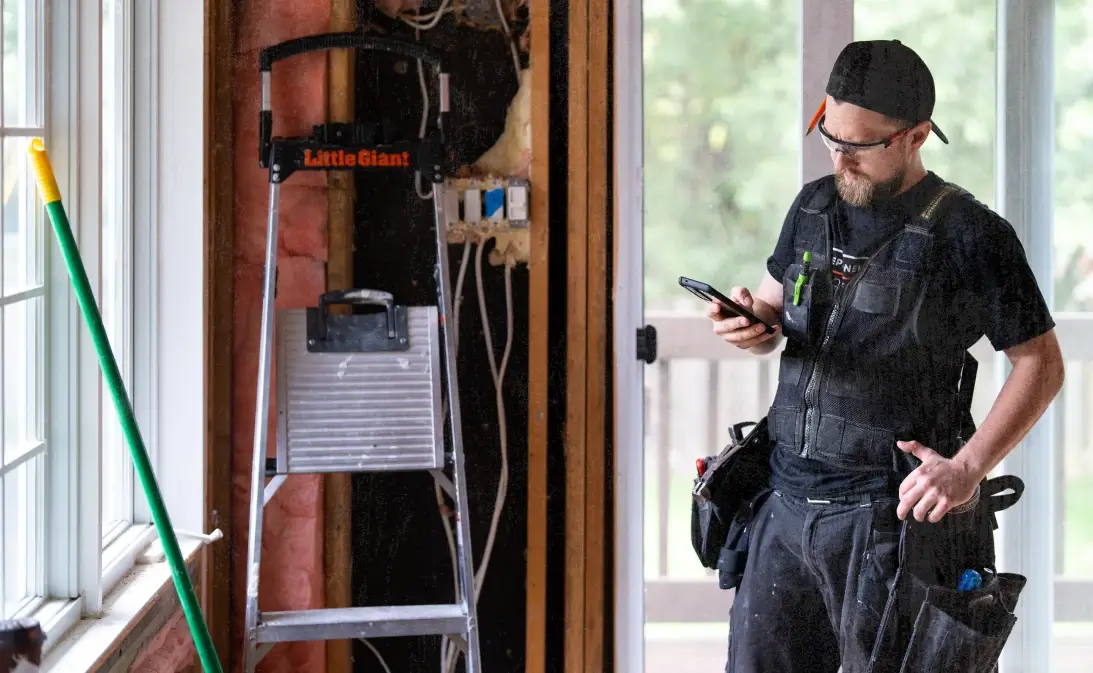 image of construction business owner using construction software on his mobile device