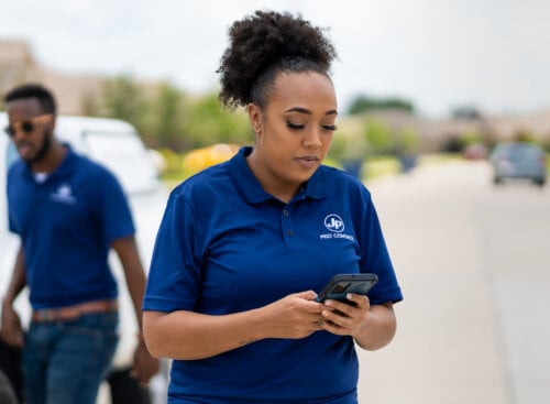 female pest control professional looking at cell phone