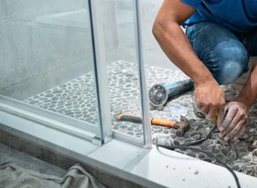 image of remodeling contractor installing flooring in shower after using Jobber's remodeling software