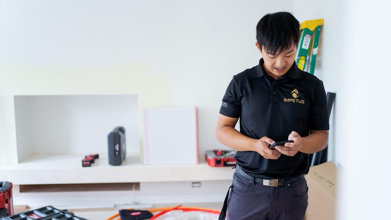 Photo of a home service professional writing an invoice with net 30 terms on his smartphone