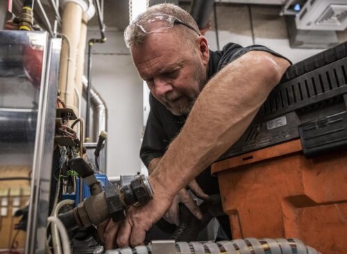 plumber working, surrounded by equipment