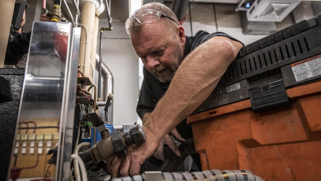 plumber working, surrounded by equipment