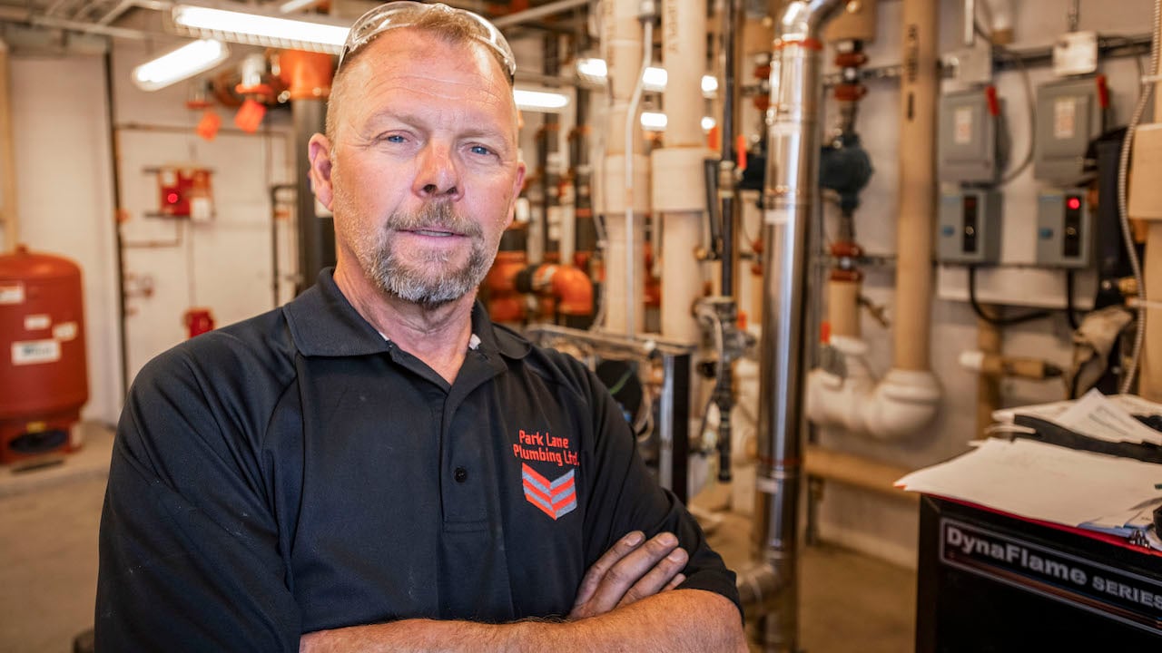 plumber standing in plumbing shop with arms folded