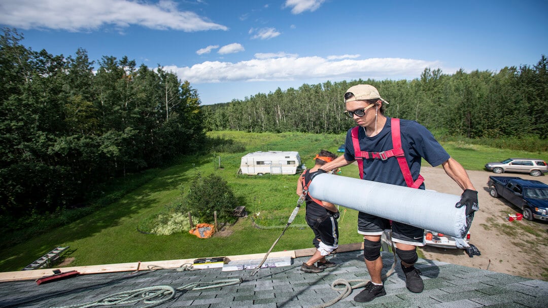 Professional roofer on a house roof