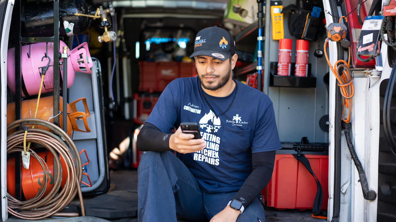 Photo of an HVAC contractor using HVAC apps on the job