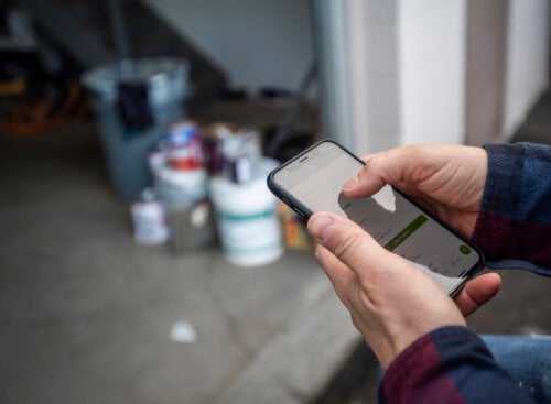 Photo of a painter looking for apps for painting contractors at a jobsite