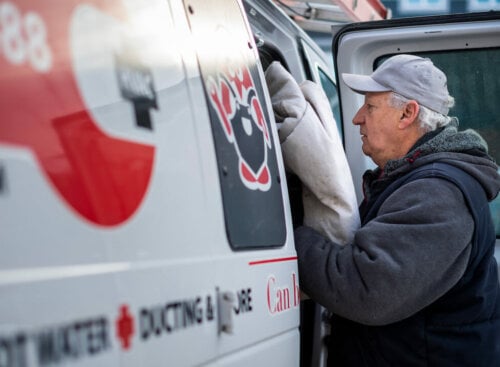 Photo of an HVAC contractor unloading equipment off his company van that's protected with HVAC insurance