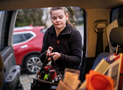 Photo of an HVAC contractor loading her HVAC truck with equipment