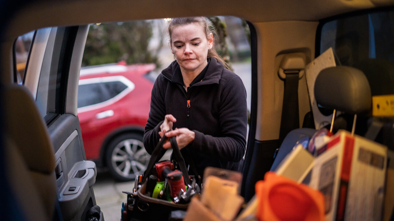 Photo of an HVAC contractor loading her HVAC truck with equipment