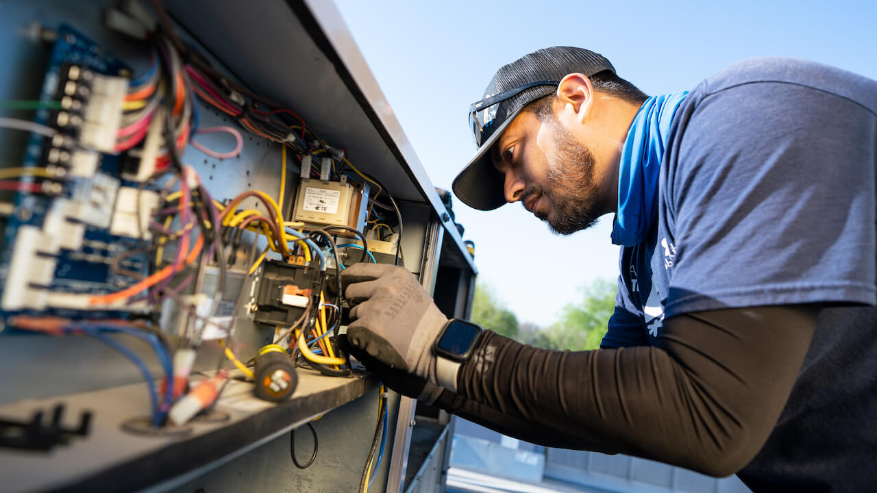 Photo of a licensed HVAC contractor repairing an HVAC system in a vehicle