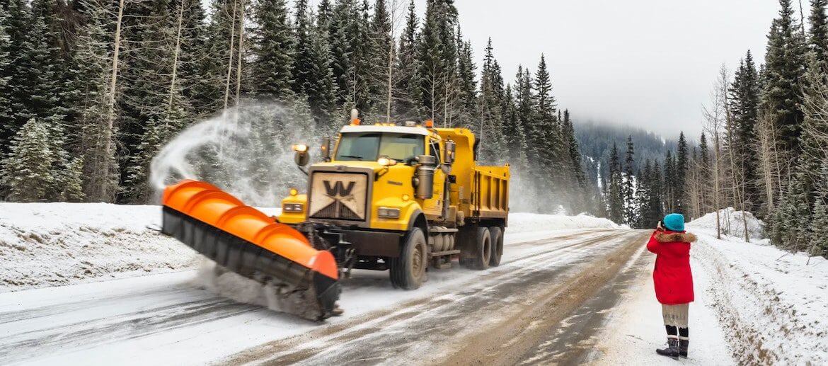 image of snow plow plowing a street