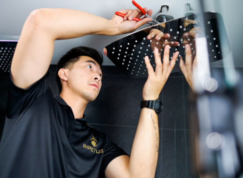image of plumber installing shower head