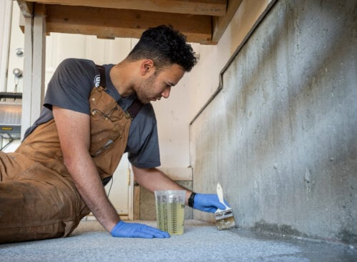 Photo of a painting contractor painting the edges of a floor for a renovation project