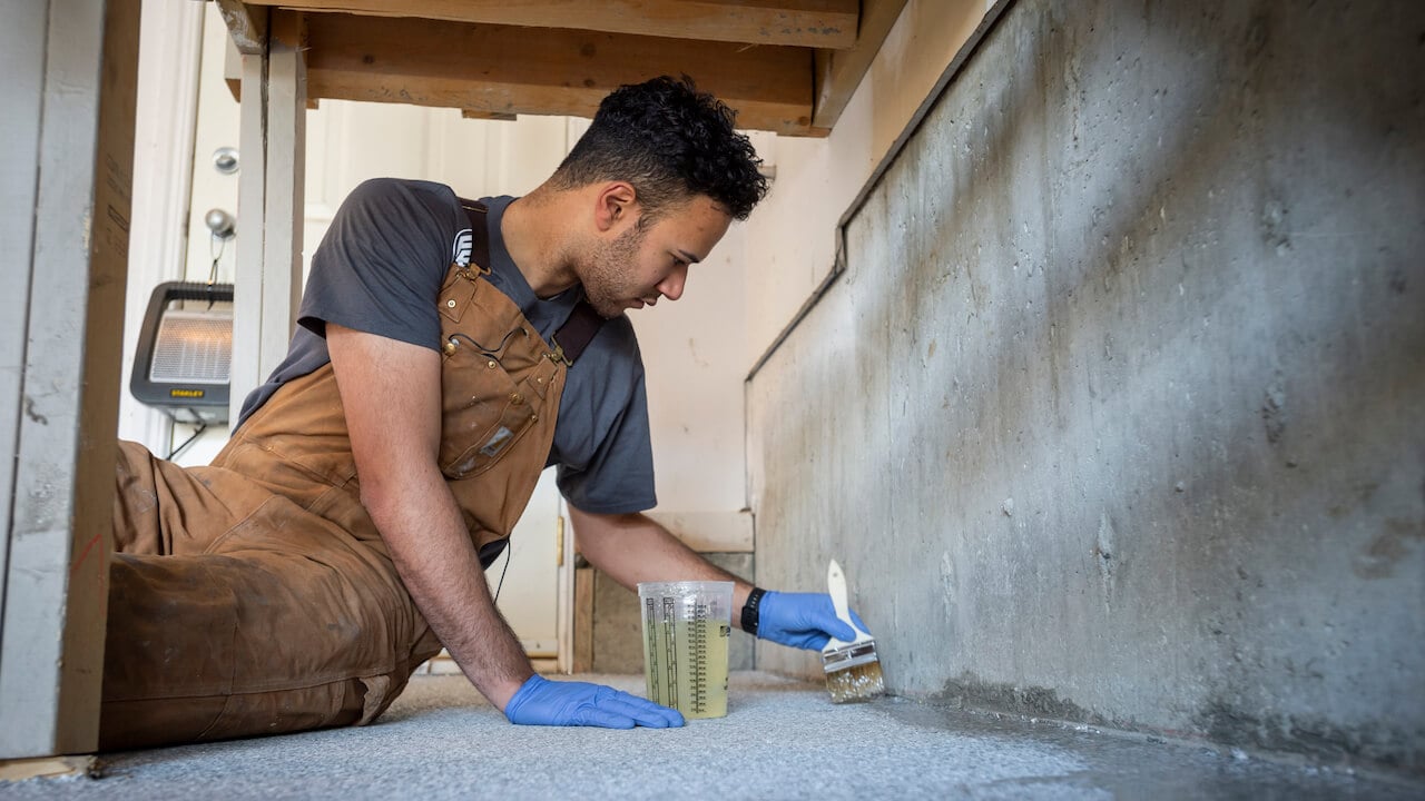 Photo of a painting contractor painting the edges of a floor for a renovation project