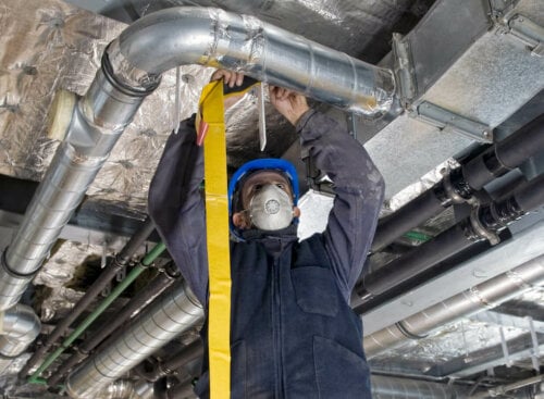 Photo of an HVAC technician working on a repair for an HVAC maintenance contract