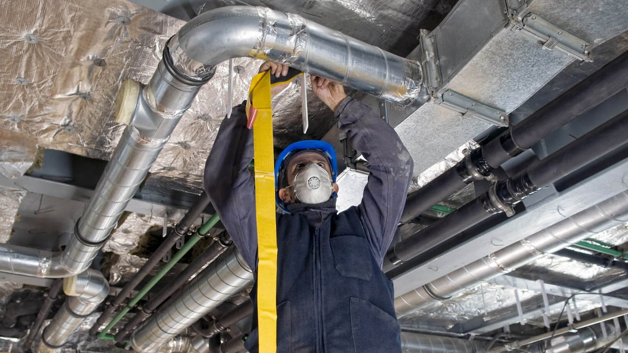 Photo of an HVAC technician working on a repair for an HVAC maintenance contract