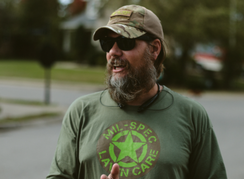 Photo of a landscaping business owner assessing a client property to price a landscaping job
