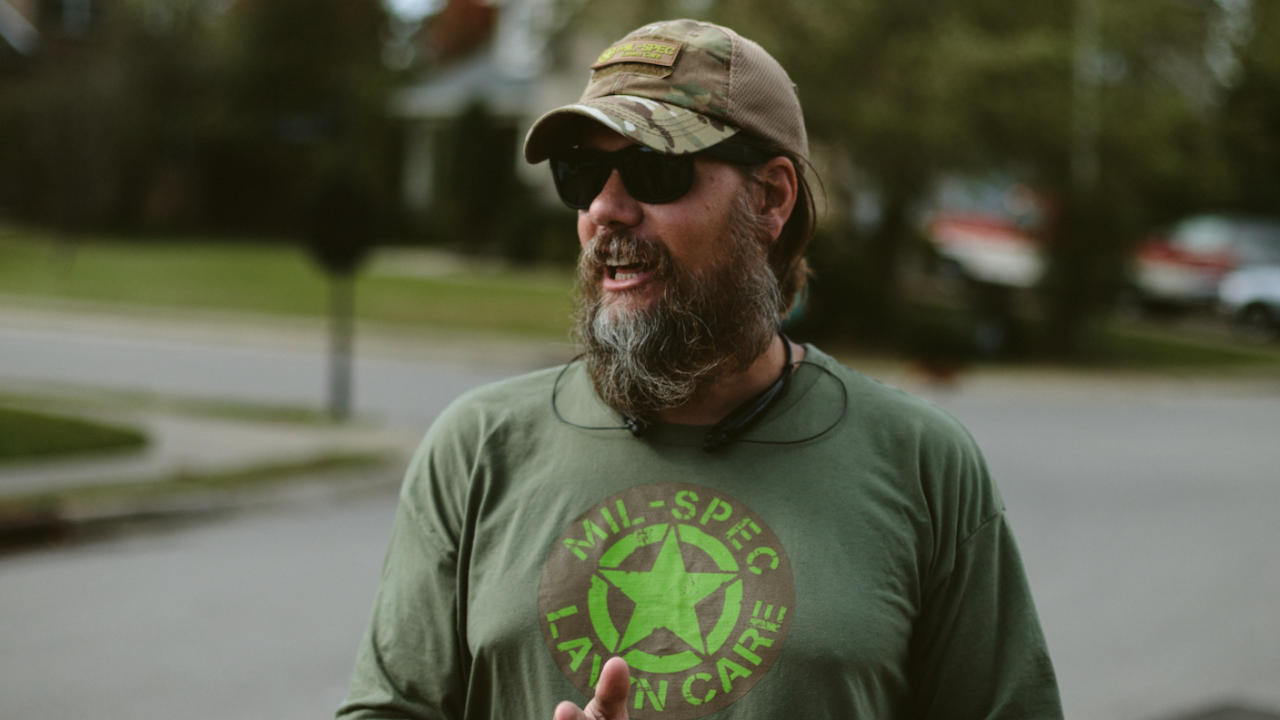 Photo of a landscaping business owner assessing a client property to price a landscaping job