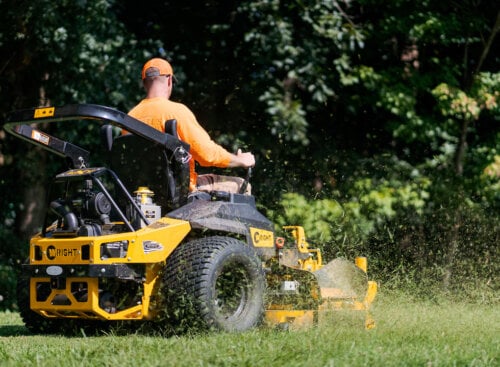 Photo of a lawn care contractor mowing a client's lawn on a riding mower