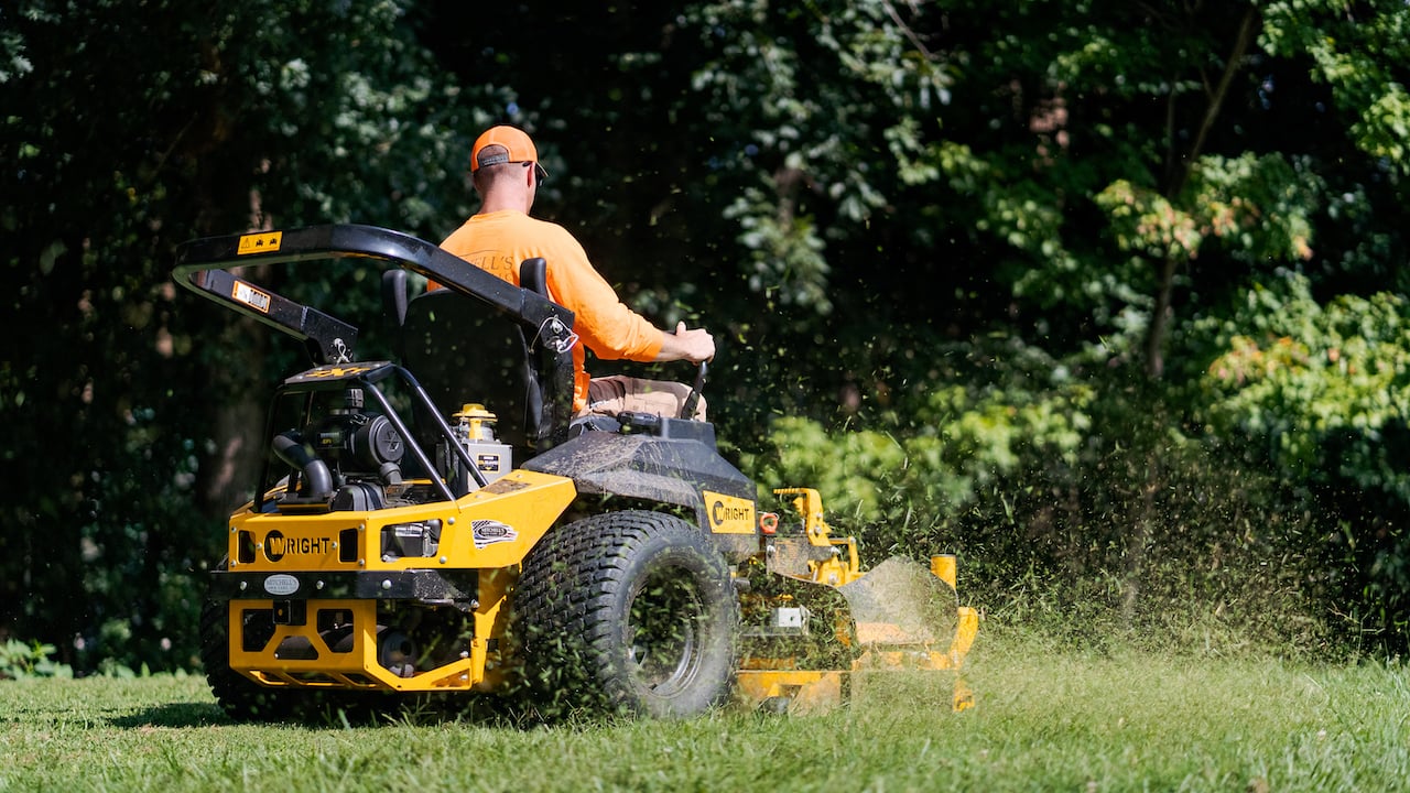 Photo of a lawn care contractor mowing a client's lawn on a riding mower