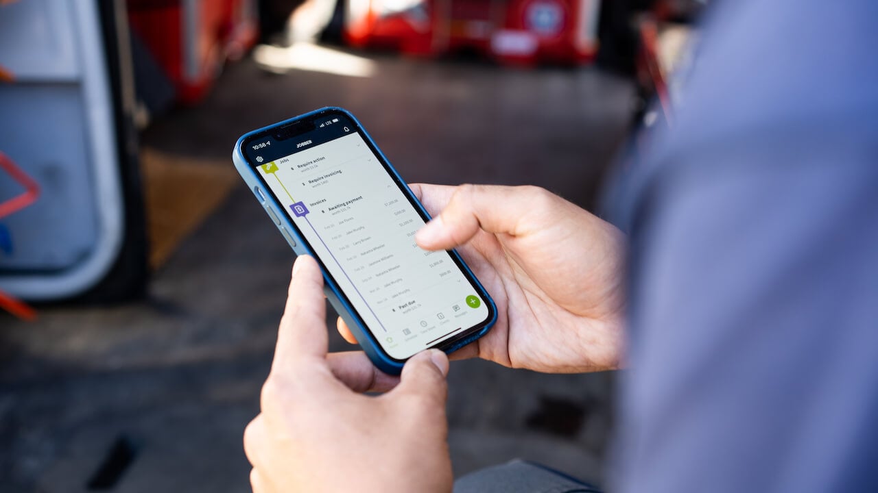 Photo of an HVAC company owner running his HVAC business using the Jobber mobile app