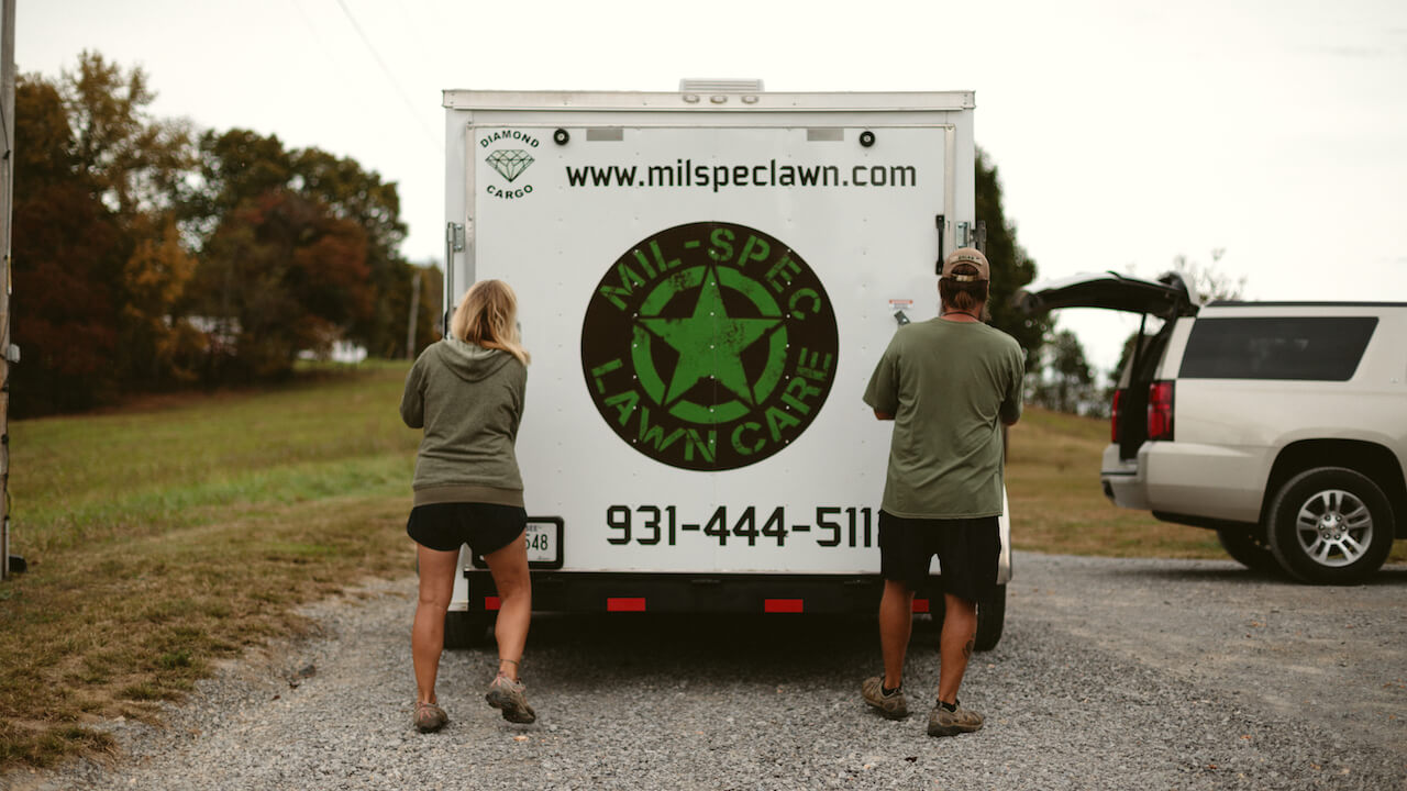 Brian and Kristy Boase of MIL-SPEC Landscaping opening their van outside a customer property to start a landscaping job