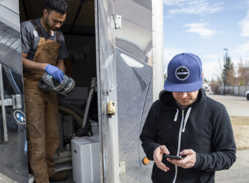 Photo of two painting contractors outside a storage locker preparing for a painting job