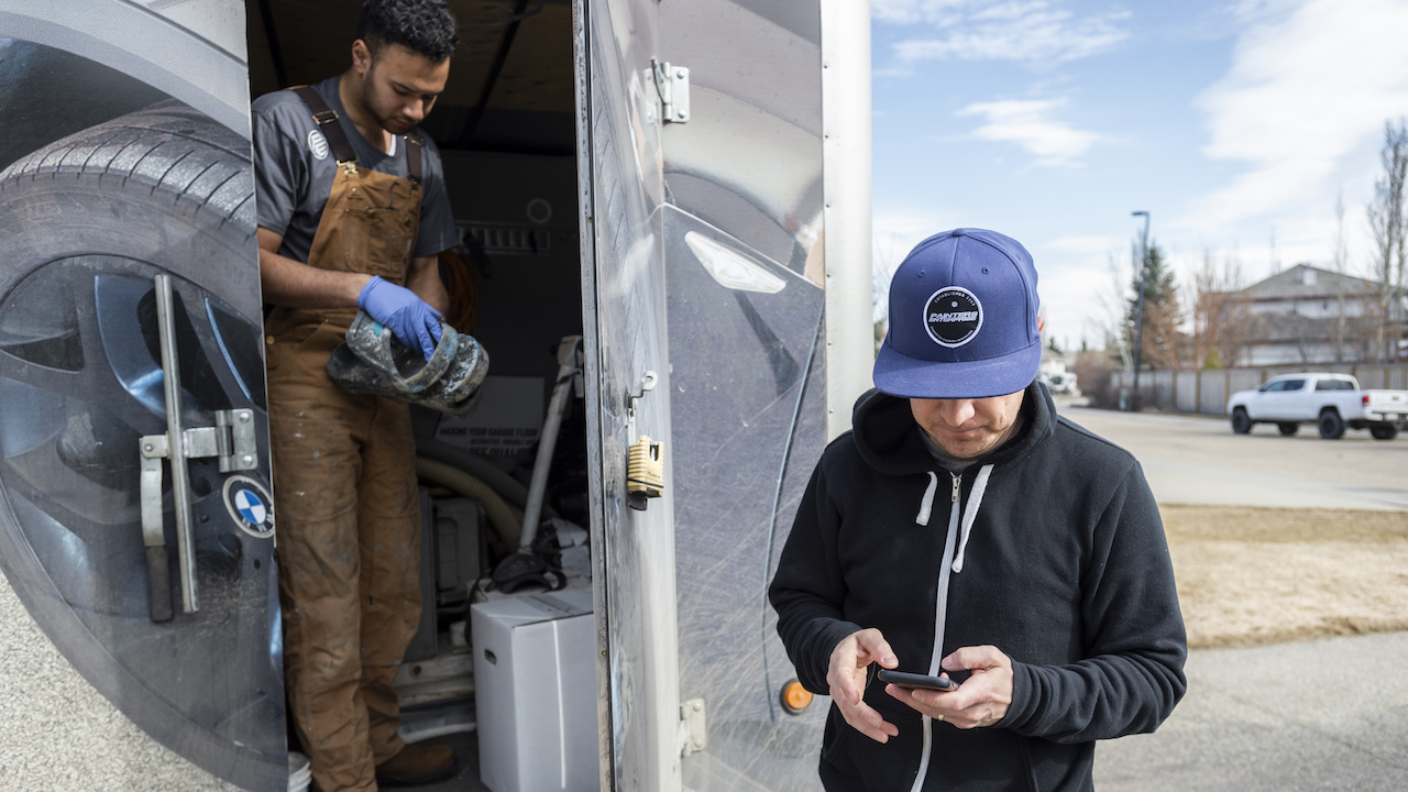 Photo of two painting contractors outside a storage locker preparing for a painting job