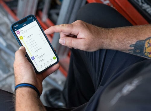 Photo of a service business owner accessing customer payments online on the Jobber mobile app