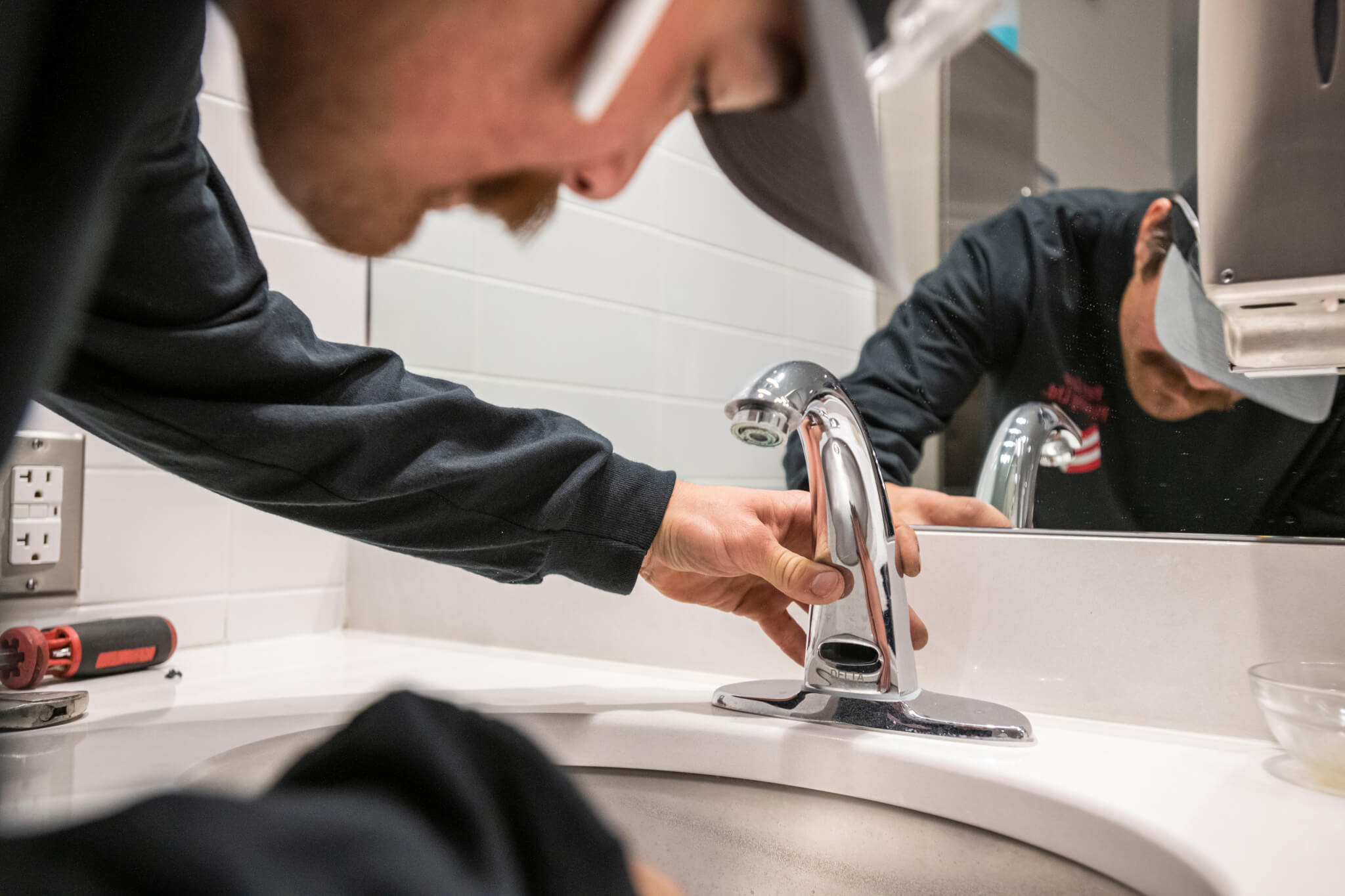 image of plumber installing faucet