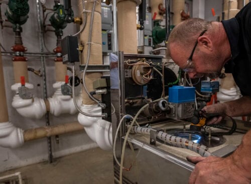 image of plumber working with safety glasses on