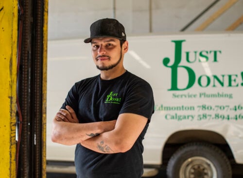 image of plumber standing in front of van with his plumbing company name on it