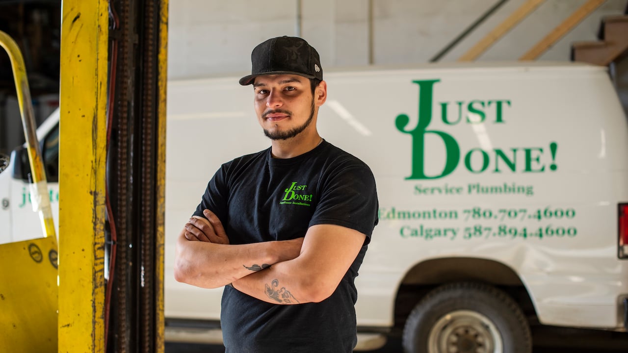 image of plumber standing in front of van with his plumbing company name on it