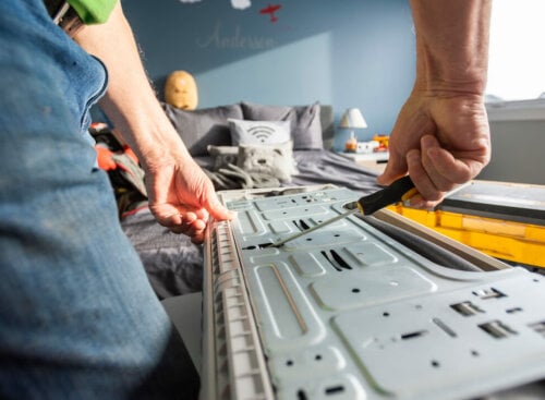 Photo of an HVAC technician repairing an air conditioning unit