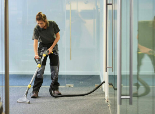 professional carpet cleaner vacuuming an office carpet