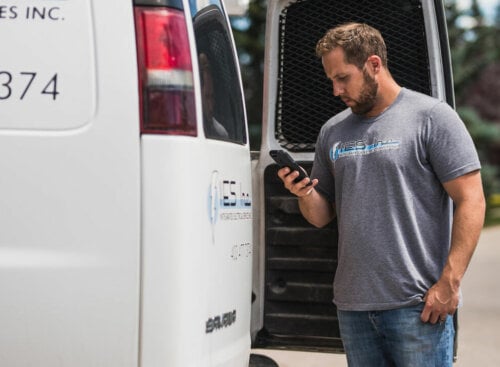 Photo of a contractor scheduling his crew on a smartphone using route optimization