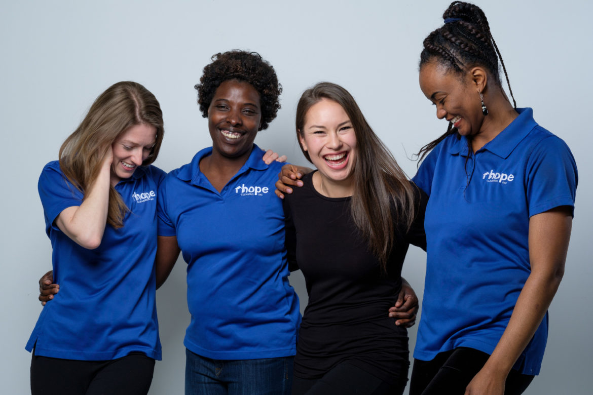group of female cleaners standing in a row, smiling