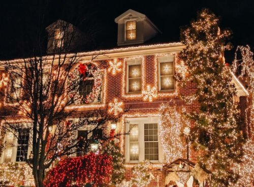 well-lit house covered in holiday lights at night