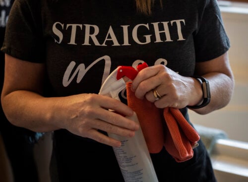 female cleaner holding spray bottle and cloth