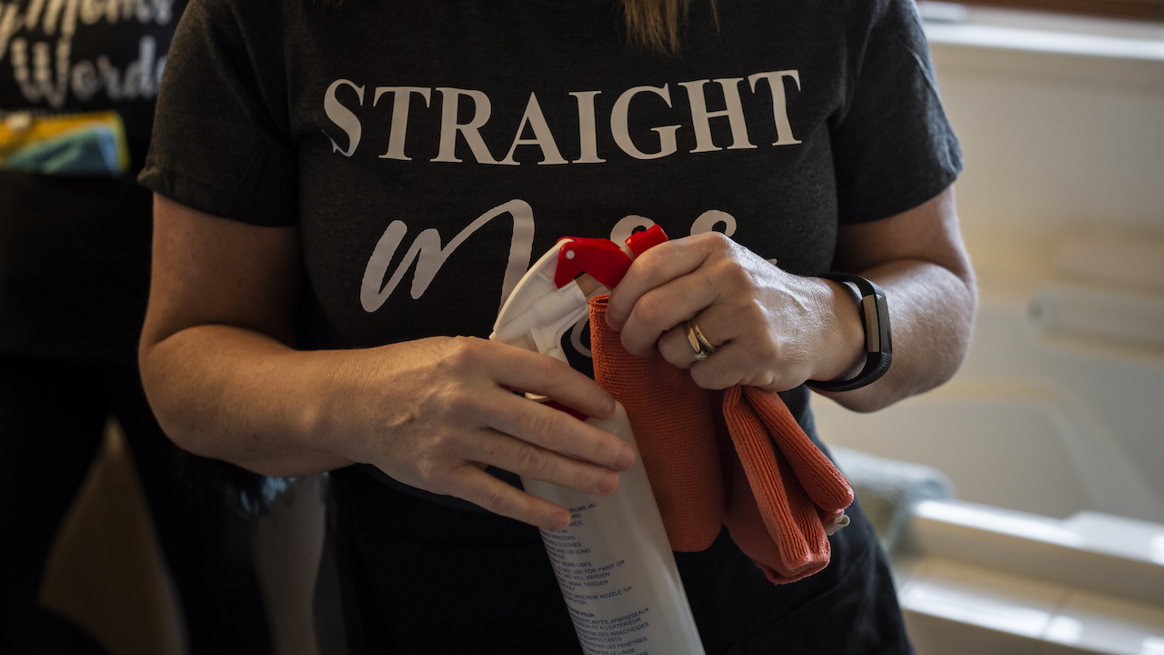 female cleaner holding spray bottle and cloth